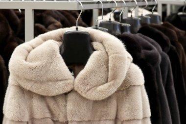 Mağazadaki askıda üst üste kürk mantolar. Kadın modası, doğal kürk giysileri indirimde.