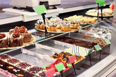 Dükkan vitrininde parlak kekler. Kapatın.