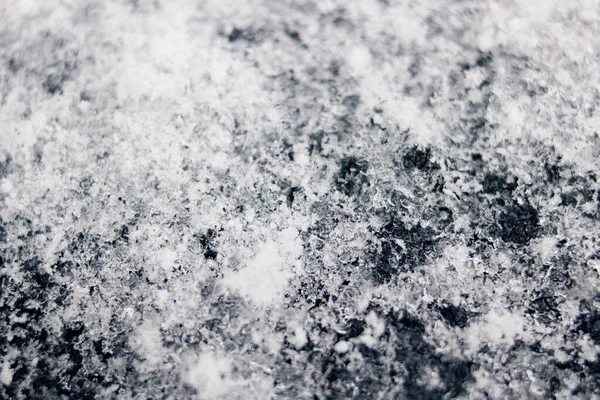 Белые снежинки на черной поверхности — стоковое фото