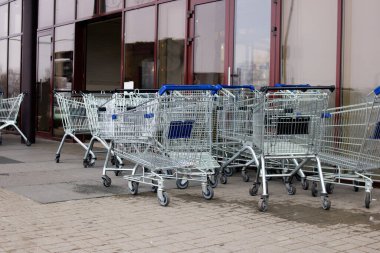 Mağaza girişinde bir sürü alışveriş arabası var.