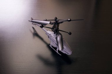 Gri oyuncak helikopter ahşap bir masada. Yakın plan.