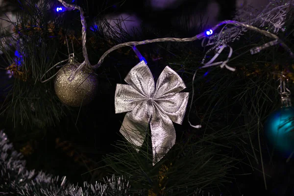 Silver bow on branch of christmas tree — Stock Photo, Image