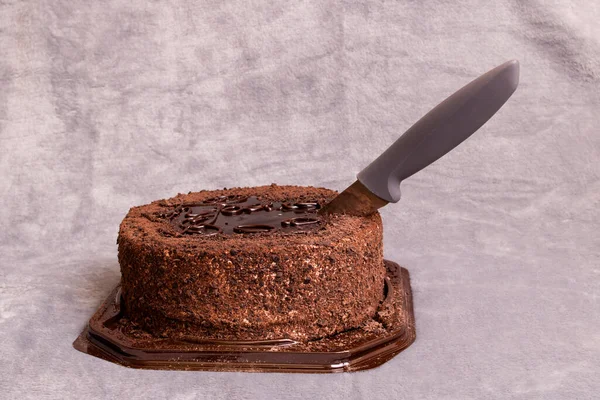 Gâteau au chocolat et couteau sur fond gris fermer — Photo