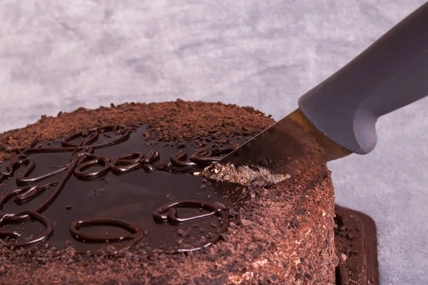 Schokoladenkuchen und Messer auf grauem Hintergrund aus nächster Nähe — Stockfoto