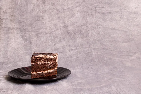 Pedaço de bolo de chocolate no fundo cinza — Fotografia de Stock