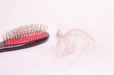 Beyaz arka planda taraklar ve saçlar. Yakın plan, opecia.