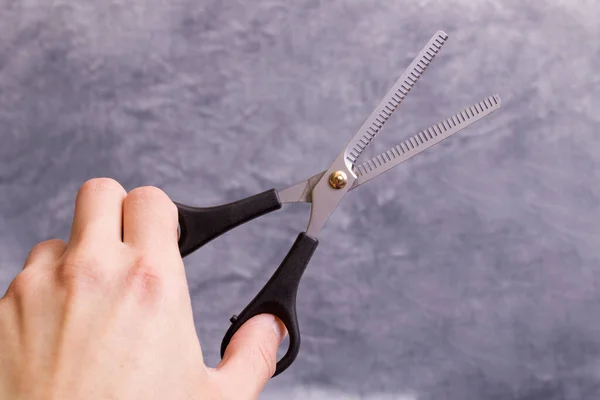 Friseurschere Der Hand Auf Grauem Hintergrund Nahaufnahme — Stockfoto