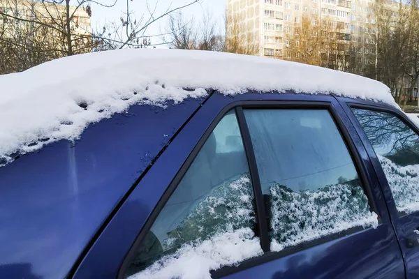 Snow on the roof and windows of the car