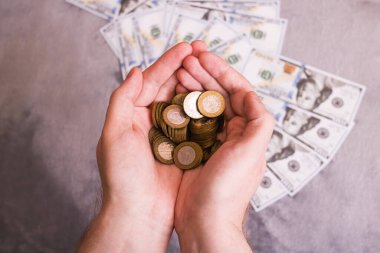 Doların arka planına karşı avuç içi bozuk para yığını