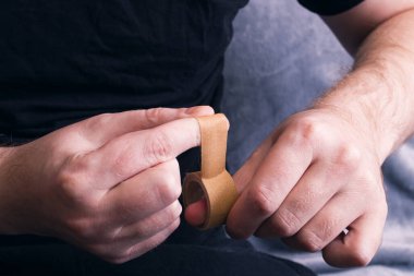 Tıbbî alçıdan eller ve bobin yakın.