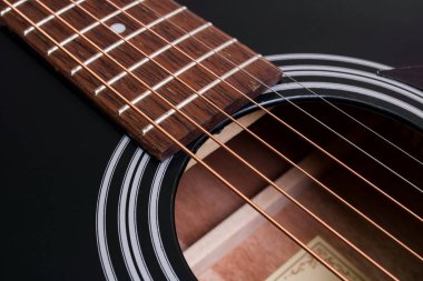 Siyah gitarda gerilmiş teller. Yakın plan.