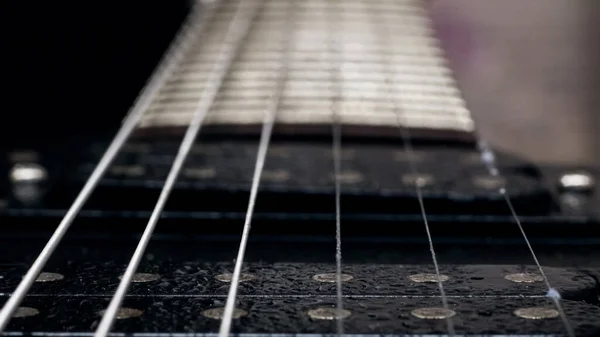 Vonósok egy fekete gitáron közelről — Stock Fotó