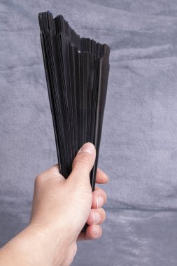 Gri arka planda siyah ahşap yelpaze var.