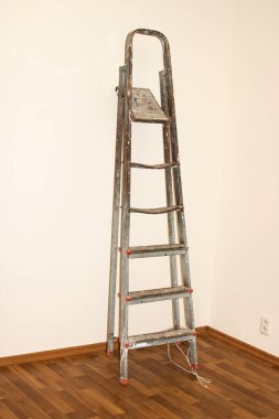 Duvara dayanan eski metal merdiven.