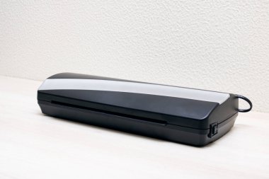 Tahta bir masada siyah kaplama cihazı. Yakın plan.