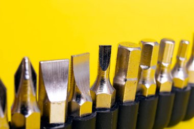 Sarı arkaplanda bir satırda tornavida parçaları kapat