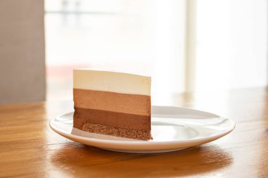 Tahta masadaki üç parça çikolatalı pasta.