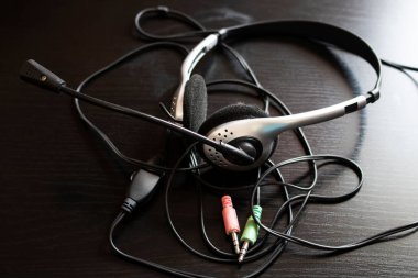 Kulaklıklar ve kablolar ahşap bir masaya yakın.