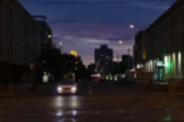 夜の道路や光の中でぼやけた背景の車 — ストック写真