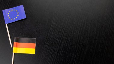Ahşap zemin üzerinde AB ve Almanya bayrağı, kopyalama alanı