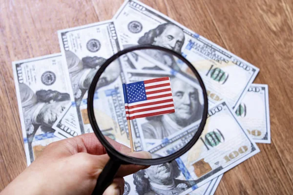 American flag, dollars and magnifying glass closeup