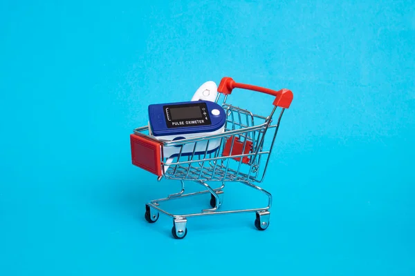 Mavi Arka Planda Alışveriş Arabasında Nabız Ölçer — Stok fotoğraf