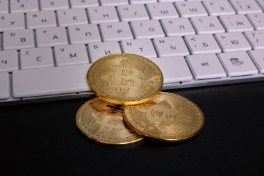 Bir bilgisayar klavyesinde üç bitcoin yakın plan