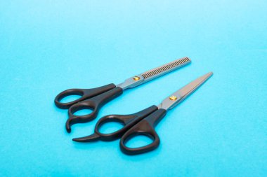 Mavi arka planda iki kuaför makası. Yakın plan.