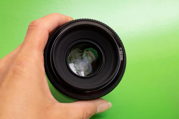 Lente Câmera Mão Fundo Verde Fechar — Fotografia de Stock