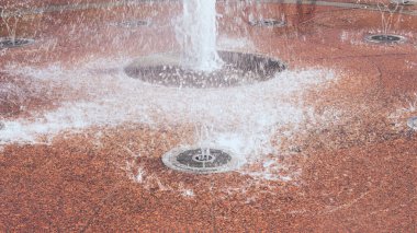 Kırmızı arkaplanda fıskiye sıçrıyor. Yakın plan.