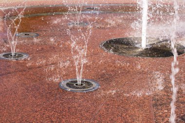 Kırmızı arkaplanda fıskiye sıçrıyor. Yakın plan.