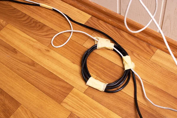 Tahta zeminde elektrik kabloları var. Yakın plan.