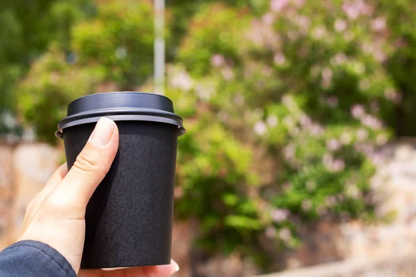 Schwarze Papiertasse Kaffee Der Hand Auf Parkhintergrund Kopierraum — Stockfoto
