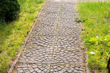 Parktaki eski fayanslı patika. Çimlerin arasına yakın.