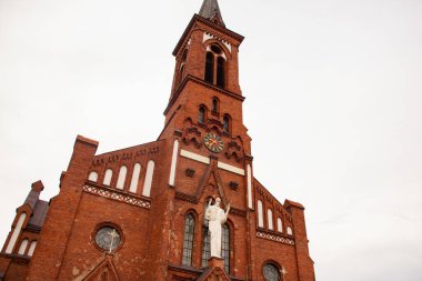 Gri arkaplanda kırmızı tuğladan yapılmış eski Katolik kilisesi