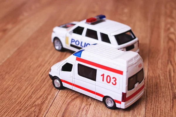 Dětské ambulance a policejní auta na dřevěné podlaze — Stock fotografie