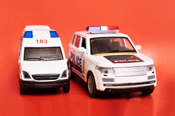 Zabawki Ambulanse Samochody Policyjne Czerwonym Tle Zbliżenie — Zdjęcie stockowe