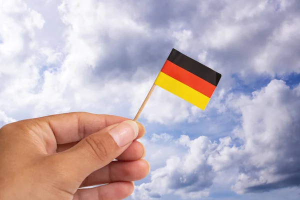 Kleine Deutschlandfahne Der Hand Auf Blauem Himmelshintergrund Nahaufnahme — Stockfoto