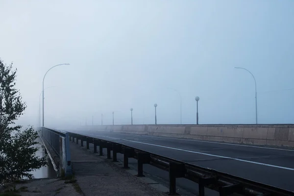 Puente y carretera en la niebla al amanecer — Foto de Stock