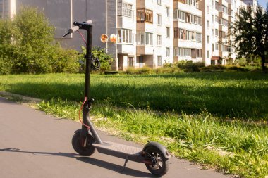 Şehrin arka planında elektrikli scooter var. Kapatın.