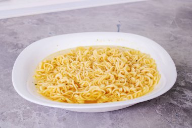 Masanın üstündeki kasede sarı yumurtalı erişte. Yakın çekim.