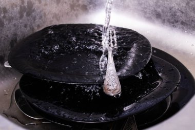 Tabaklar lavaboda, musluğun altında. Yakın çekim.