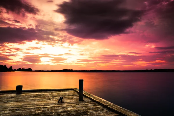Пирс на озере и красивый закат — стоковое фото