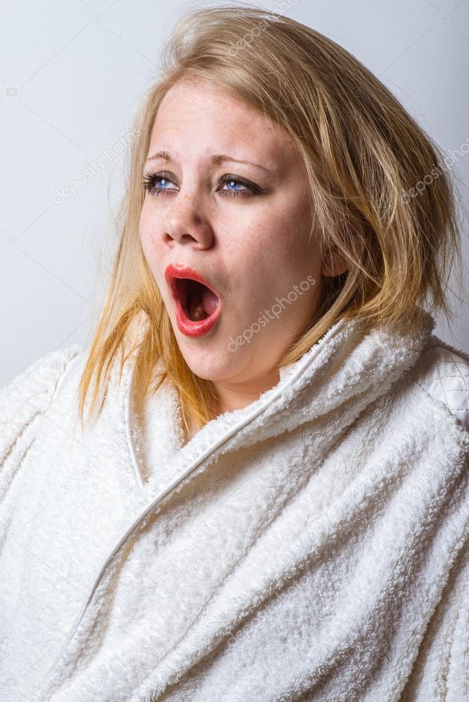 very tired woman in bathrobe looking towards the light