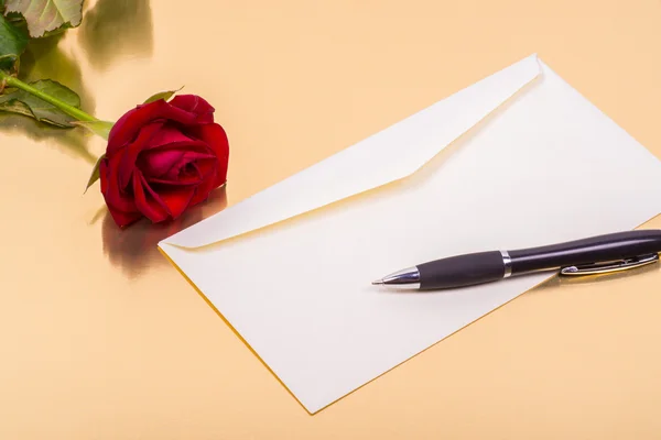 Love letter and a rose on a golden background — Stock Photo, Image