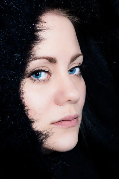 siyah bir kukuleta ile yarı profilde genç kadın