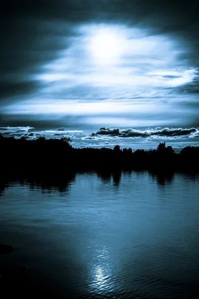 Mondschein in den Wolken über einem See — Stockfoto