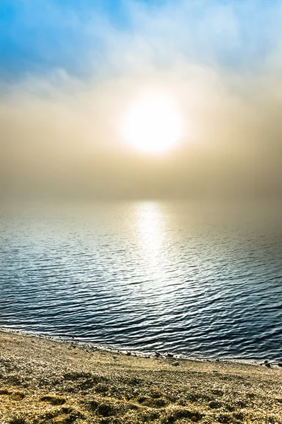 Magical morning on a beach with a veil of mist over a lake — Stock Photo, Image