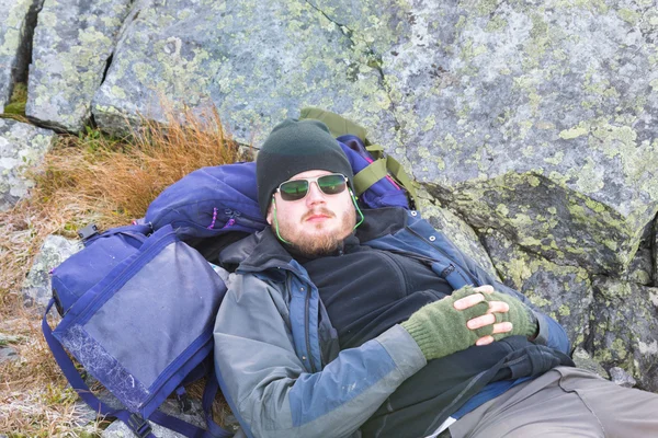 Ember, nagy sziklák körülötte pihenő — Stock Fotó