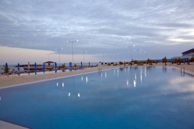 Bulutların yansıması havuza düşer. Yüzme havuzu. Sonsuzluk havuzundaki bulut yansımaları. Lüks açık havada sonsuzluk yüzme havuzu